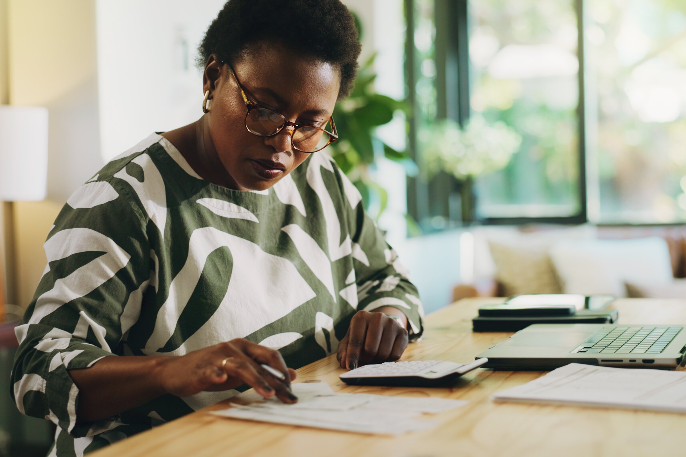 Eine Frau präsentiert ihrem Team Geschäftsgrafiken auf einem großen Bildschirm.