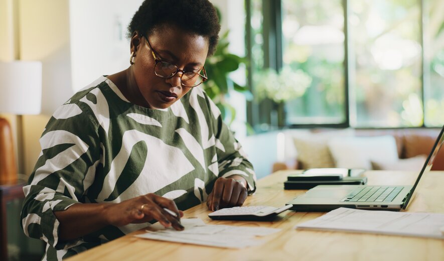 Eine Frau präsentiert ihrem Team Geschäftsgrafiken auf einem großen Bildschirm.