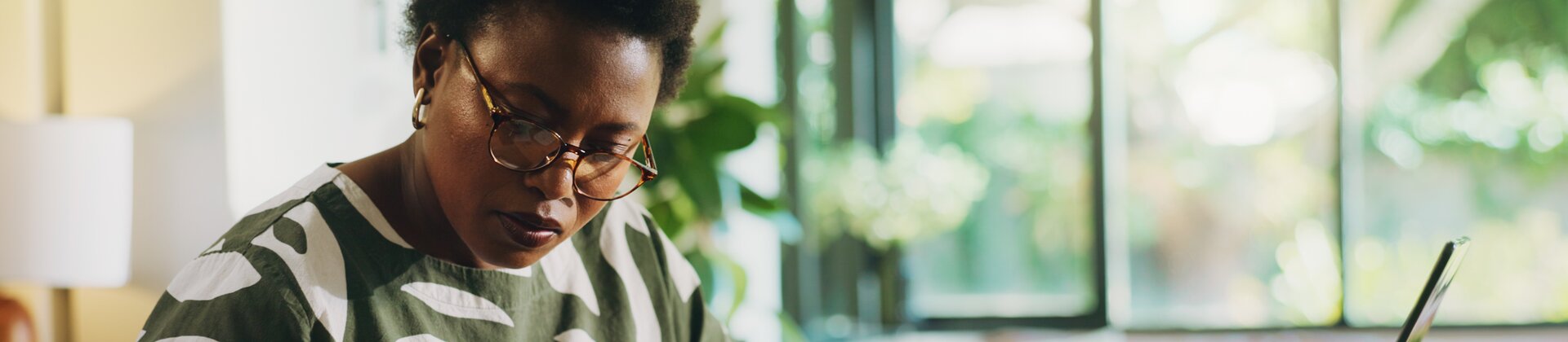 Eine Frau präsentiert ihrem Team Geschäftsgrafiken auf einem großen Bildschirm.