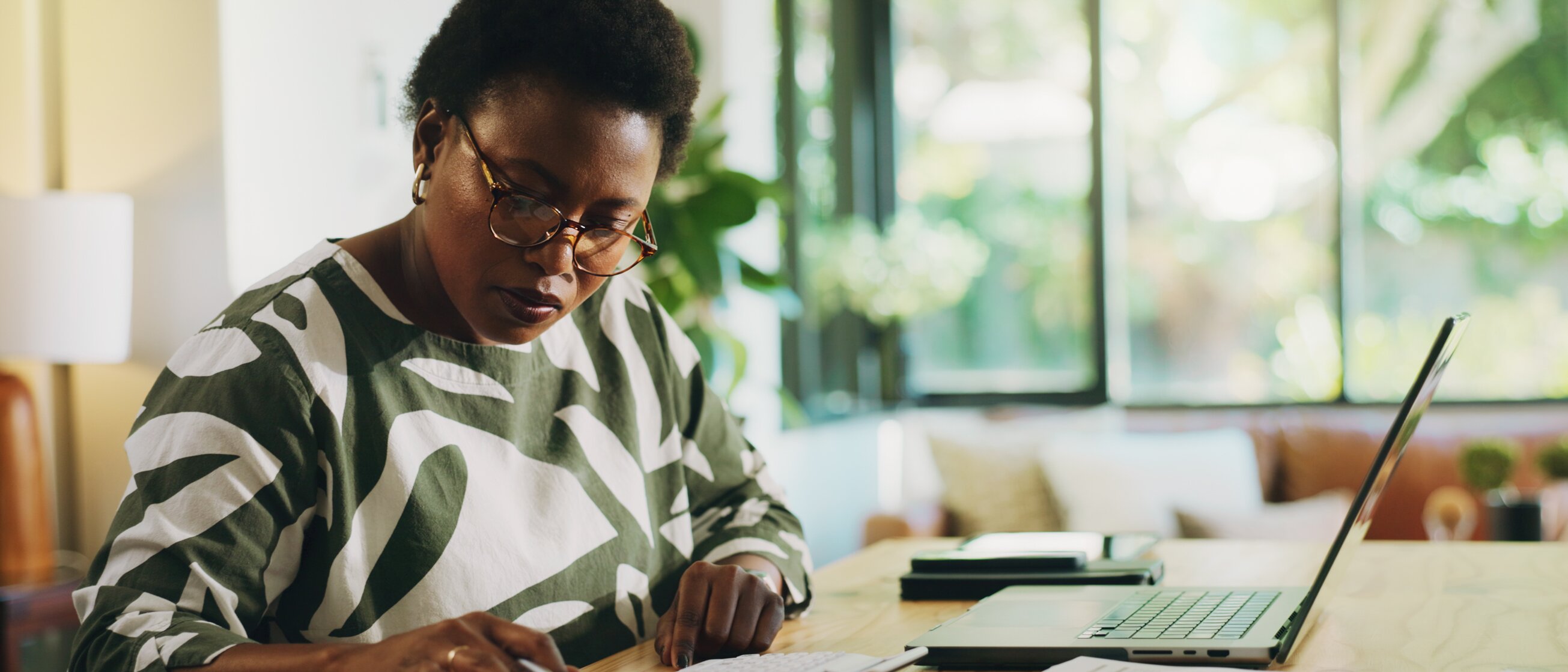 Eine konzentrierte Finanzexpertin analysiert Bilanzunterlagen am Schreibtisch – Sinnbild für die Weiterbildung zur Gepr. Bilanzbuchhalterin IHK, die fundiertes Wissen in Bilanzierung, Steuerrecht und Unternehmenssteuerung vermittelt.