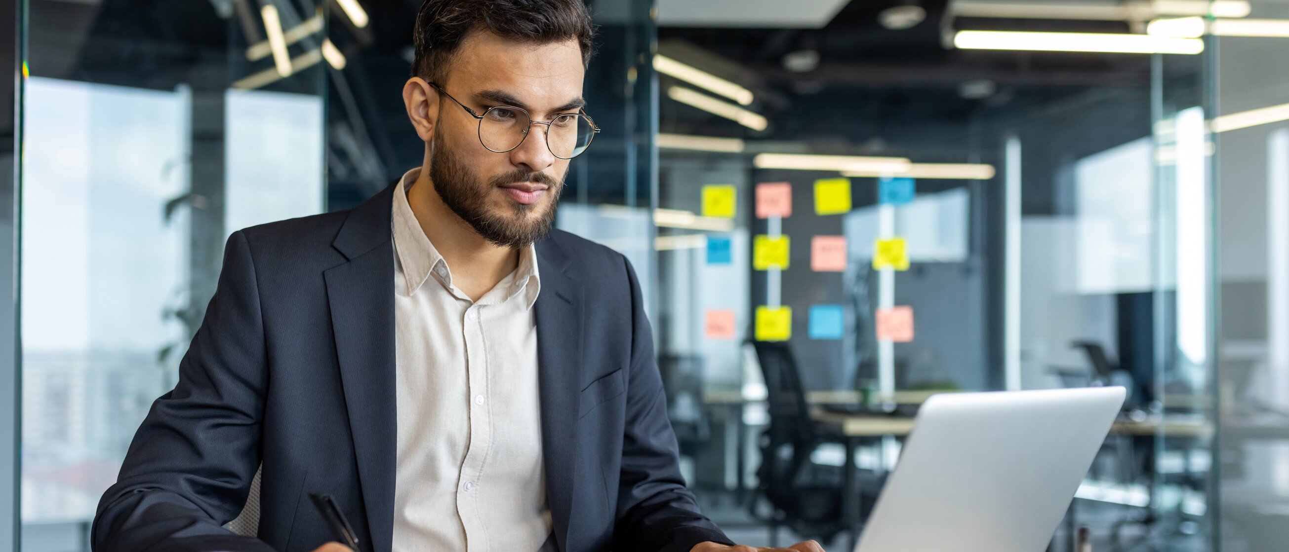 Ein Mann im Anzug arbeitet konzentriert am Laptop – Weiterbildung zum geprüften Fachmann für Versicherungsvermittlung nach § 34d GewO für fundierte Beratungskompetenz und rechtssichere Vermittlung.