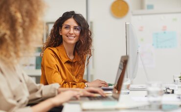 Berufstätige Frau arbeitet am Computer im Büro – Sinnbild für Controlling-Weiterbildungen, um betriebliche Kennzahlen zu analysieren und fundierte Entscheidungen zu treffen.