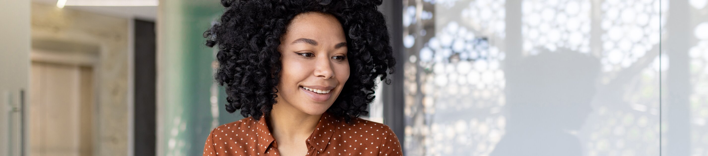 Das Bild zeigt eine Person, die konzentriert am Schreibtisch arbeitet und dabei sowohl einen Laptop als auch einen Taschenrechner benutzt.