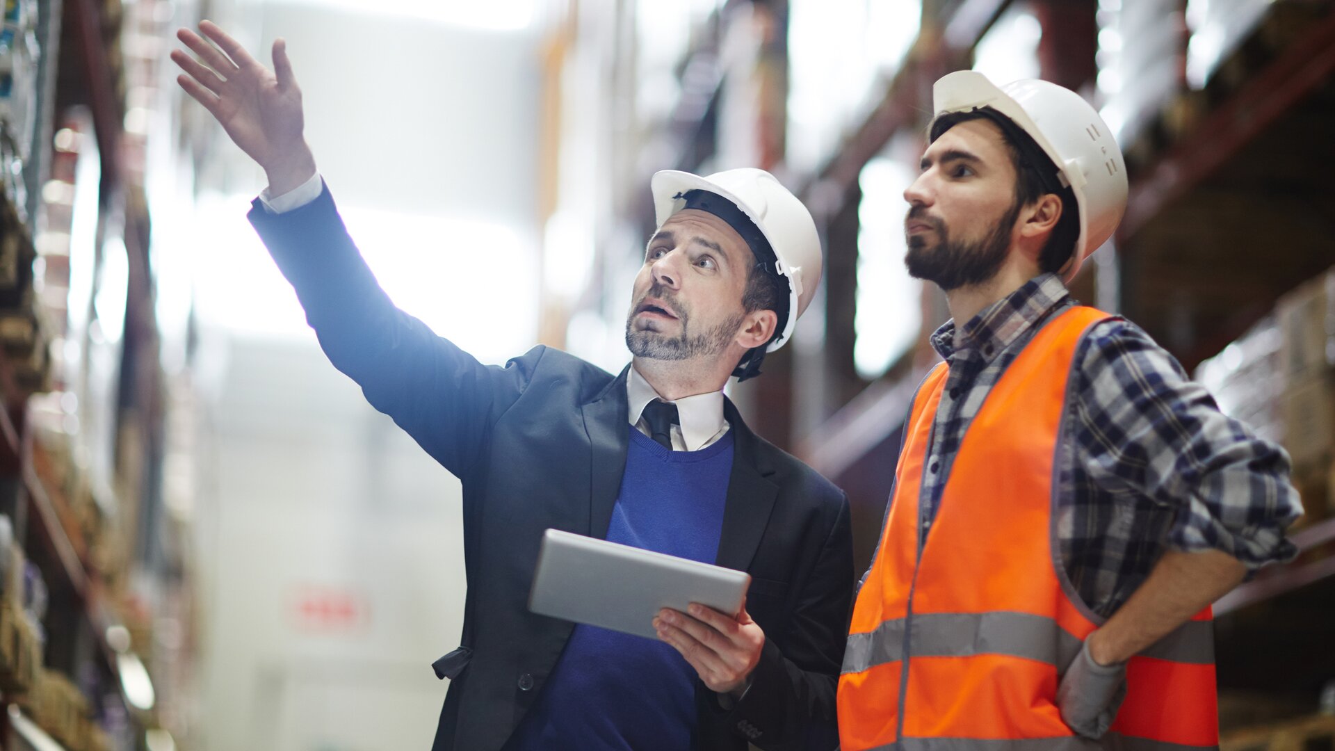 Ein Supervisor und ein Mitarbeiter inspizieren gemeinsam ein Lagerregal.