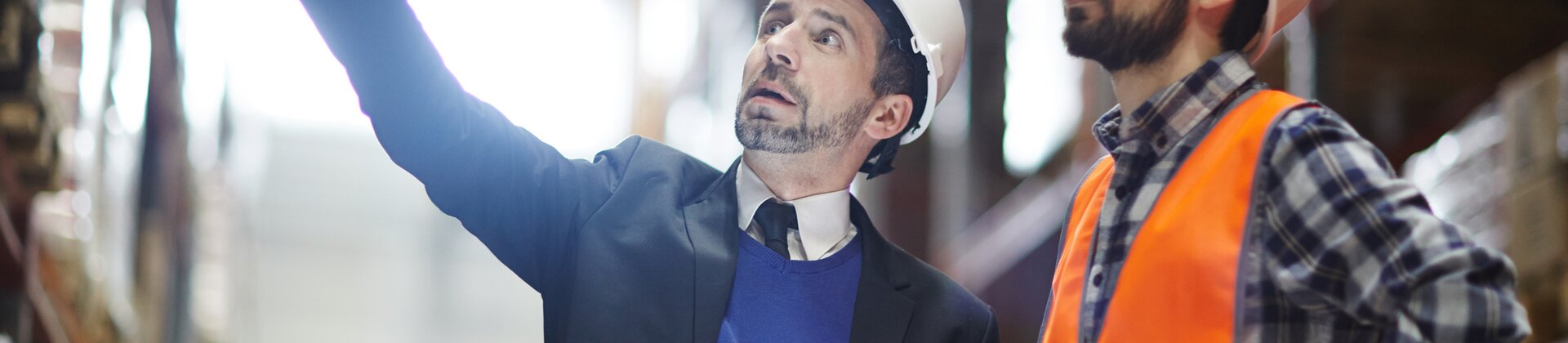 Ein Supervisor und ein Mitarbeiter inspizieren gemeinsam ein Lagerregal.