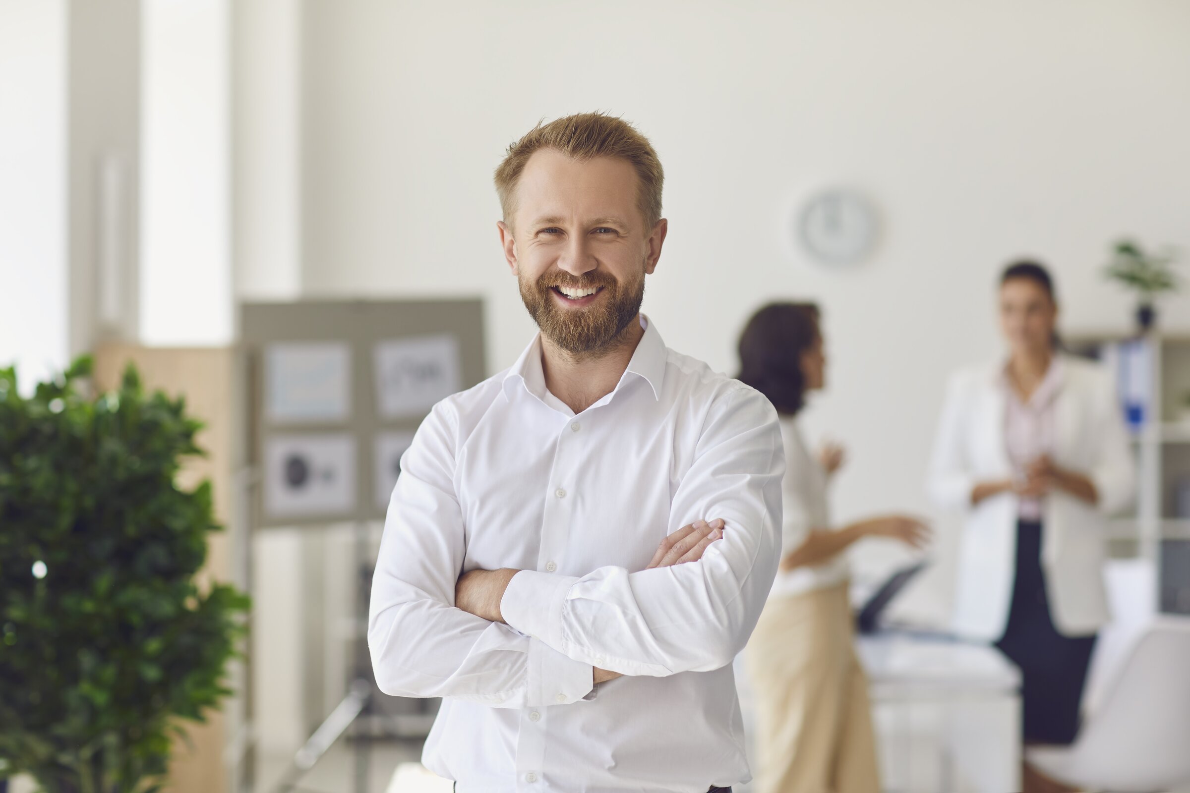 Ein Mann präsentiert Diagramme an einer Pinnwand, während drei Kolleginnen aufmerksam zuhören.