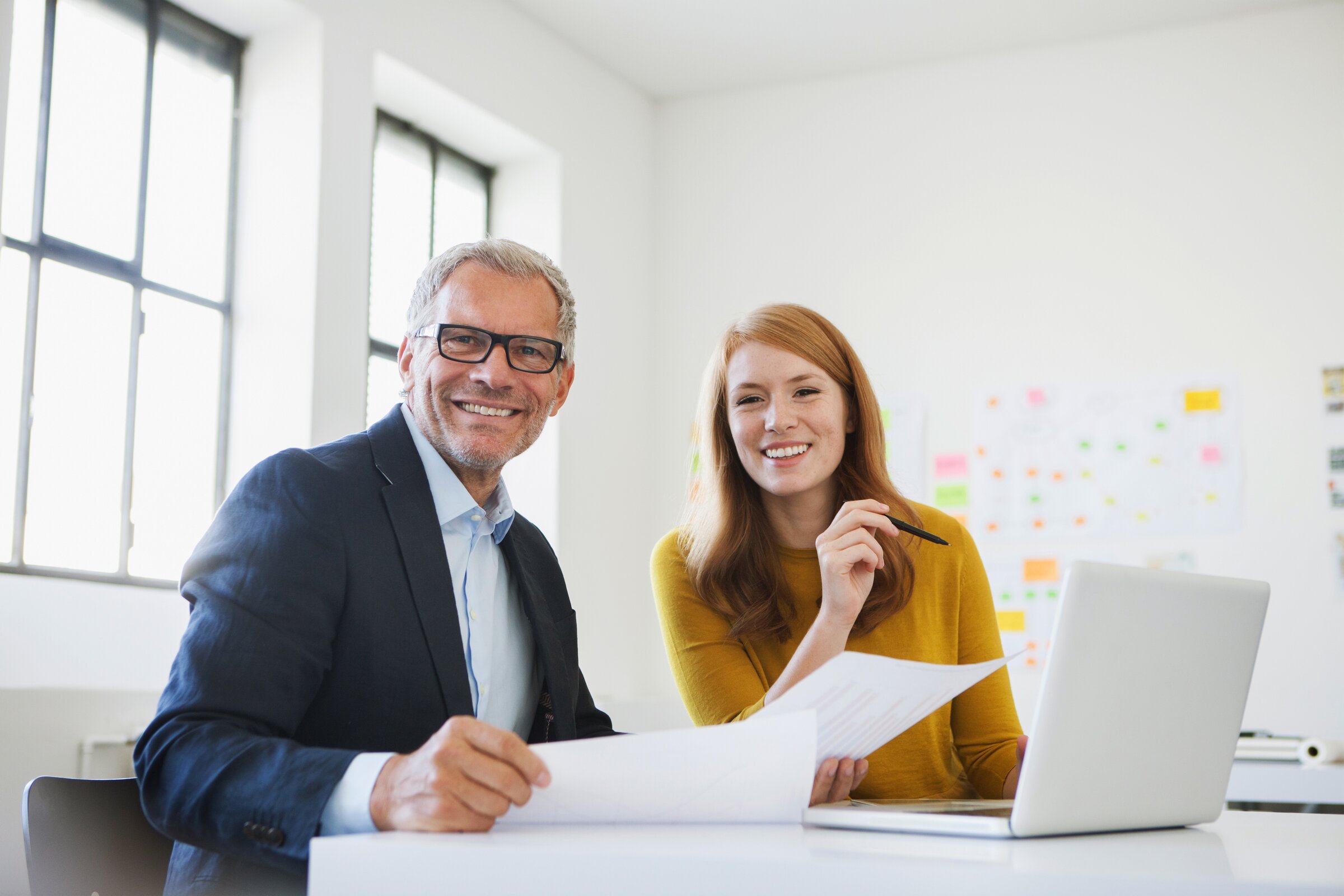 Zwei technische Betriebswirt/-innen nebeneinander am Schreibtisch