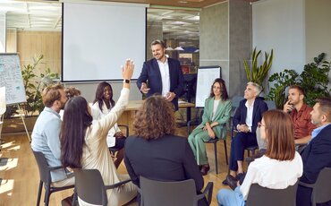 Ein Coach spricht in entspannter Atmosphäre mit einer Person im Büro – Sinnbild für professionelles Coaching, persönliche Entwicklung und vertrauensvolle Beratung.