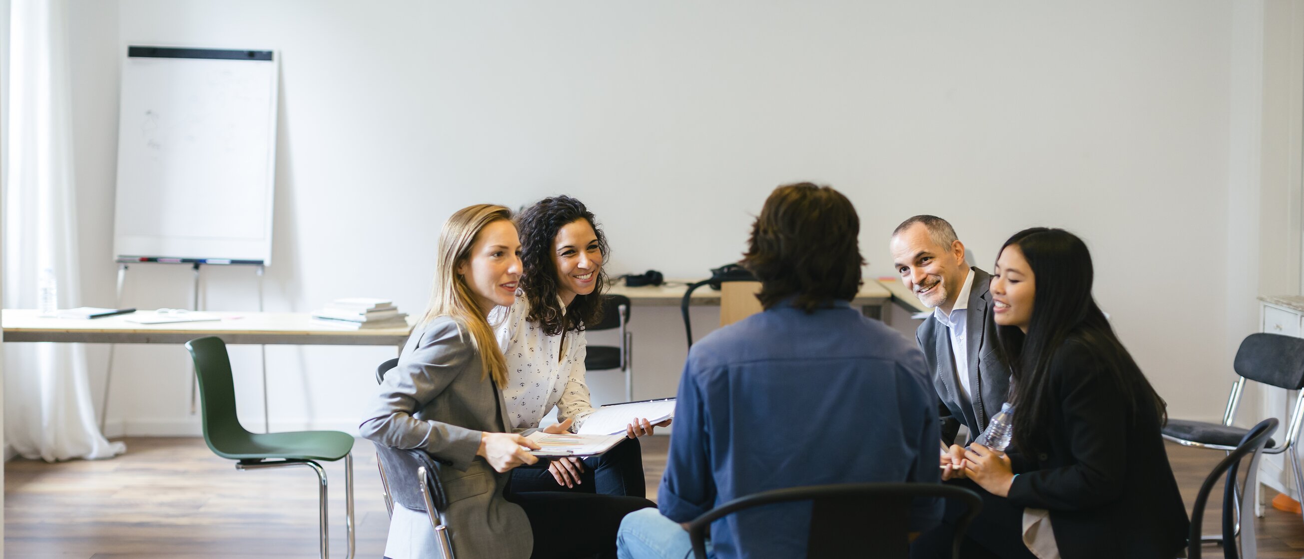 Eine kleine Gruppe sitzt im Stuhlkreis und führt ein gemeinsames Gespräch in entspannter Atmosphäre.