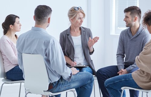 Das Bild zeigt eine kleine Gruppe von Menschen, die in einem Stuhlkreis sitzt und sich in einem Gespräch austauscht.