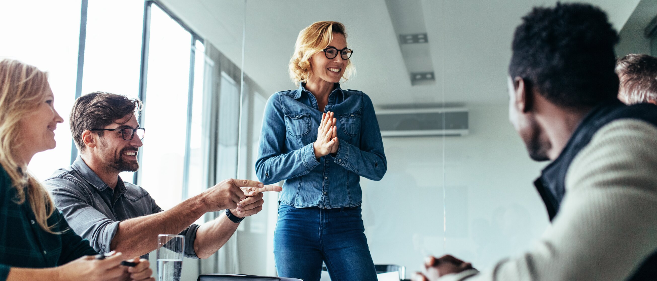 Teammeeting im modernen Seminarraum der IHK Akademie Traunstein am Campus Chiemgau mit lächelnder Referentin.