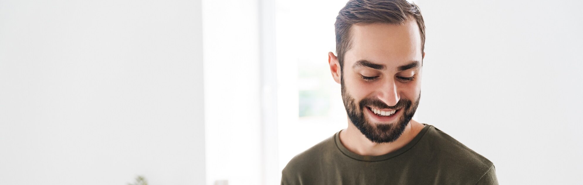 Ein junger Mann liest gut gelaunt in einer Broschüre.