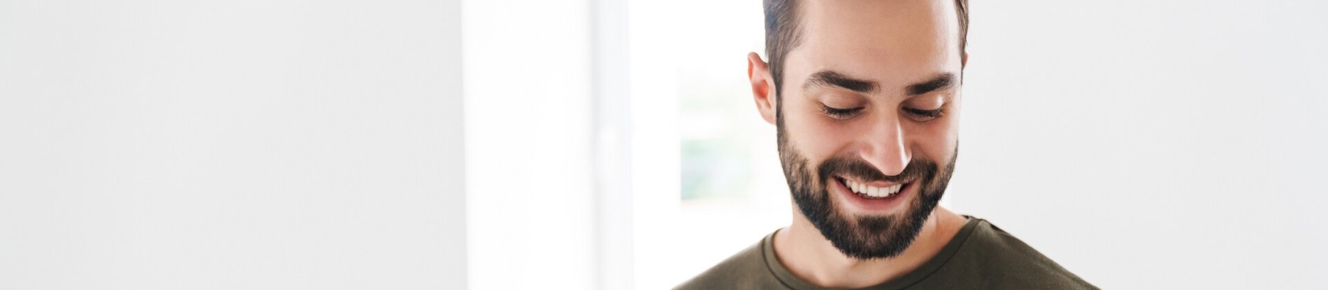 Ein junger Mann liest gut gelaunt in einer Broschüre.