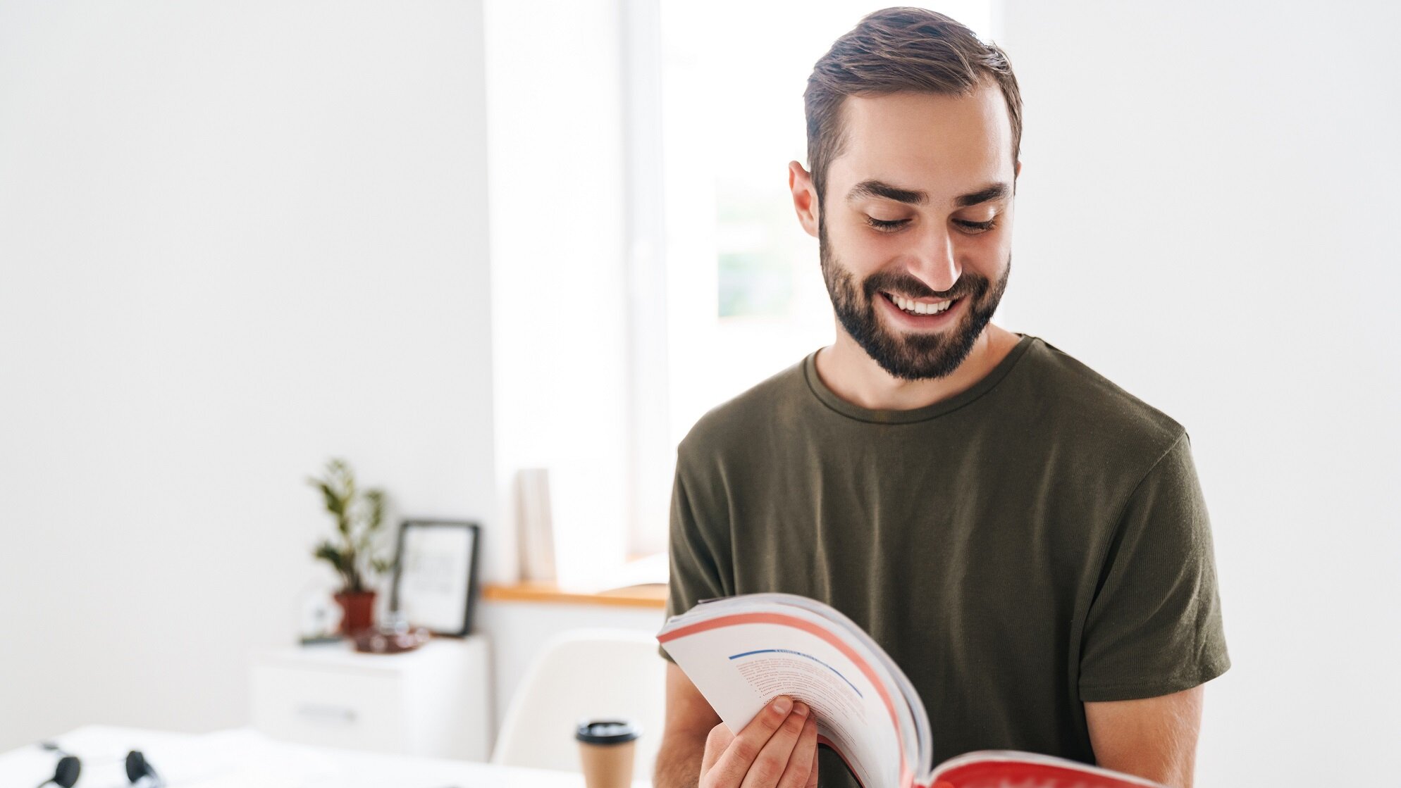 Gepr. Wirtschaftsfachwirt/-in steht mit Unterlagen in einem modernen Büro.