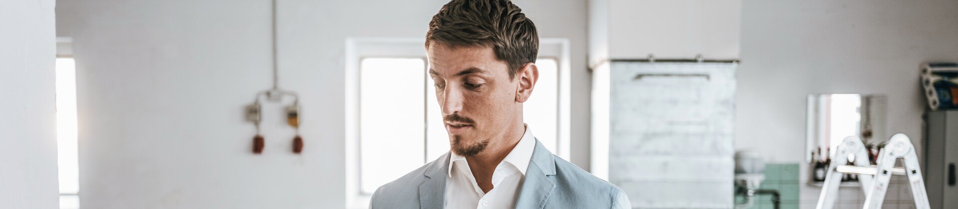 Immobilienverwalter inspiziert Objekt mit Laptop in renovierungsbedürftigem Raum