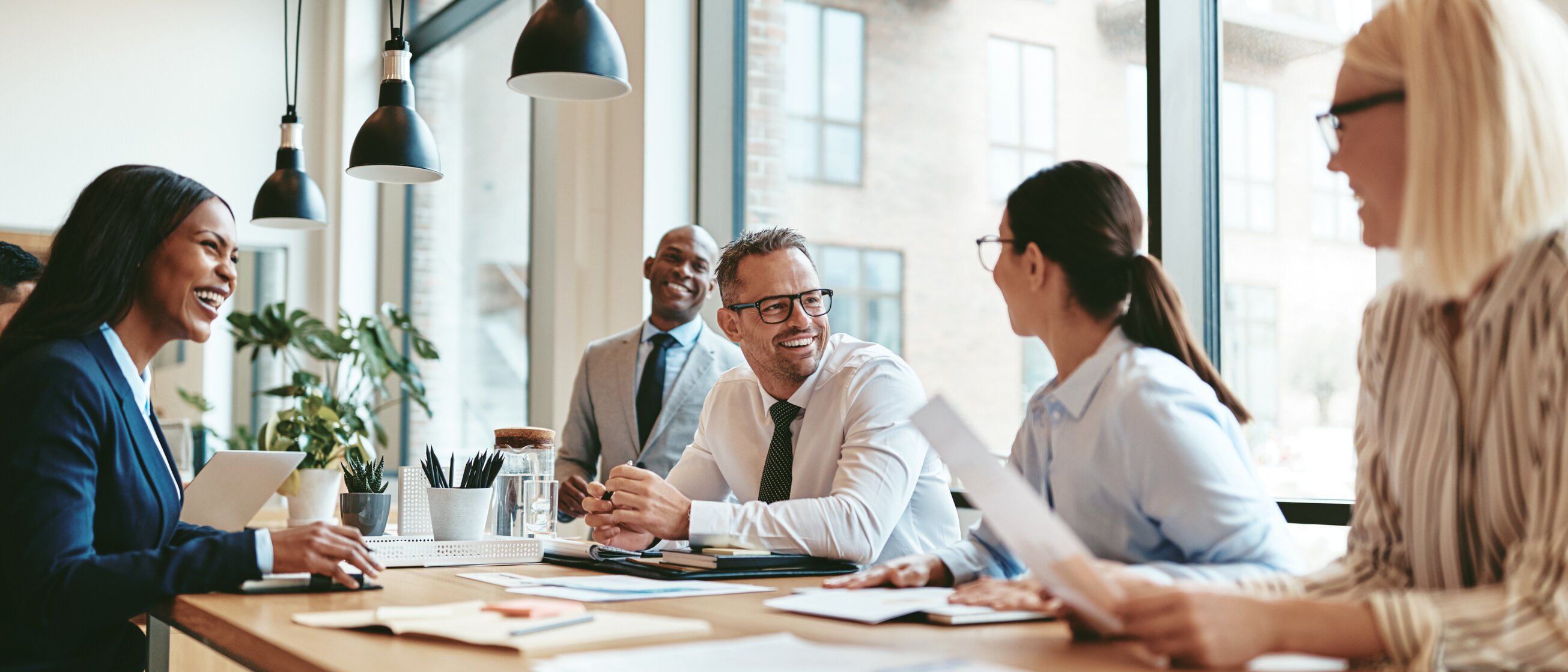 Weiterbildung im Bereich Immobilienmanagement: In einem Meeting besprechen Kolleg/-innen Managementthemen