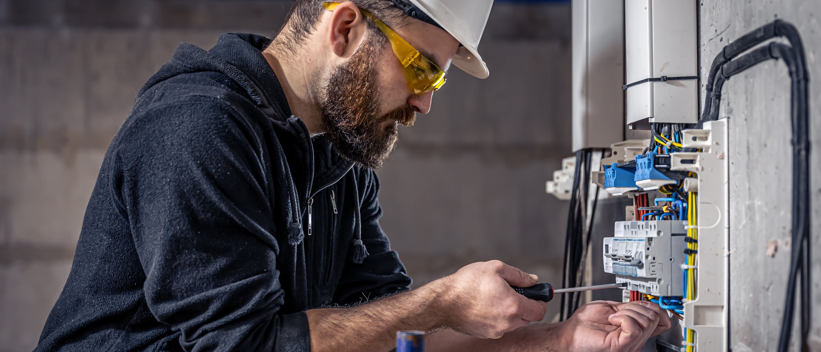 Weiterbildung Industriemeister Elektrotechnik - Industriemeister arbeitet an einem Stromkasten. 