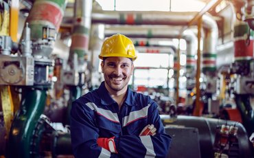 Fachkraft in Schutzkleidung und Helm in industrieller Metallproduktion als Symbol für Aufgaben im Metallbereich