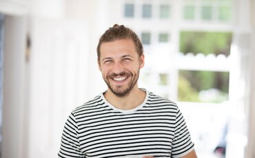 Lächelnder Mann in hellem Umfeld als sympathisches Porträt für den Bereich (Industrie-)Meister