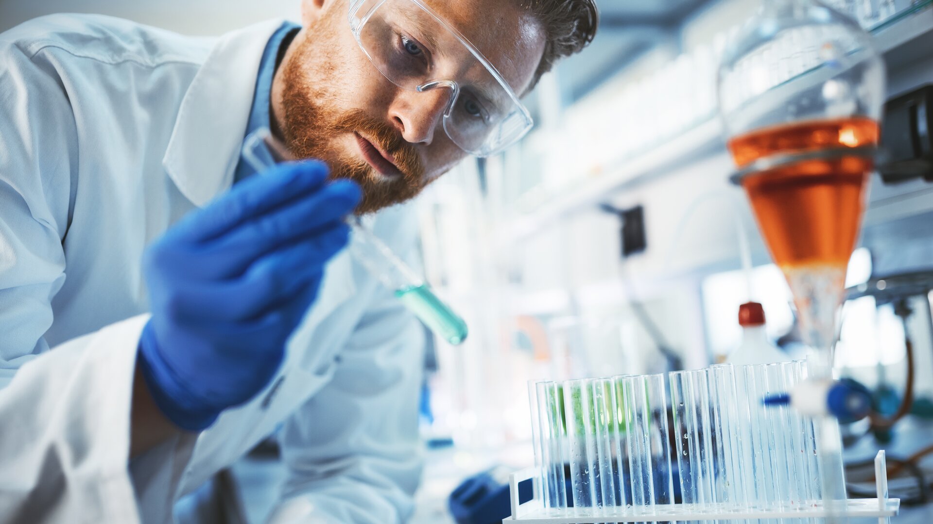 Wissenschaftler im Labor analysiert Probe mit Pipette und Reagenzgläsern