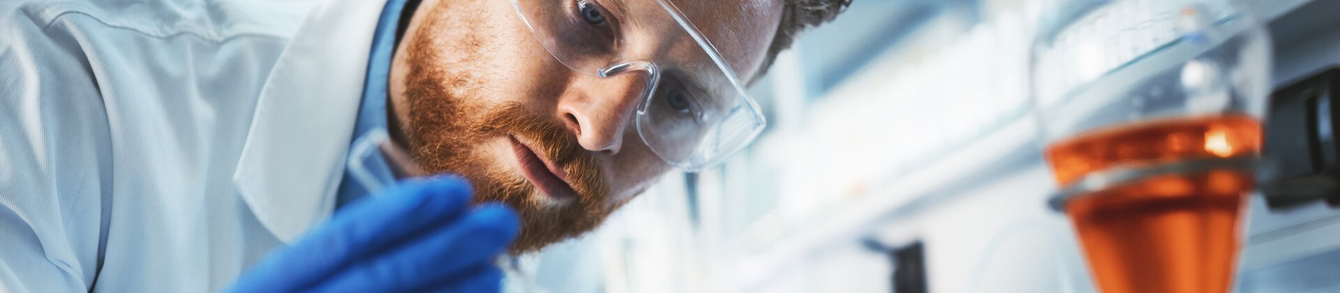 Wissenschaftler im Labor analysiert Probe mit Pipette und Reagenzgläsern