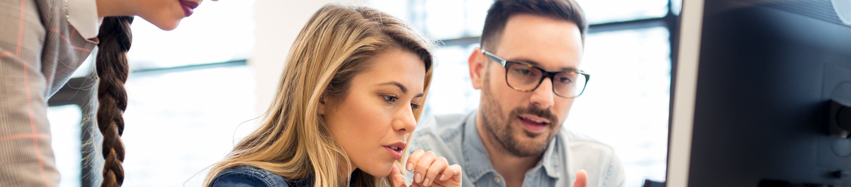 Team arbeitet gemeinsam am Computer an einem Projekt im modernen Büro