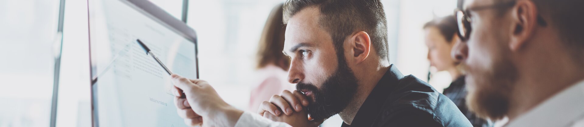 Team analysiert Daten und Diagramme am Computer im modernen Büro.