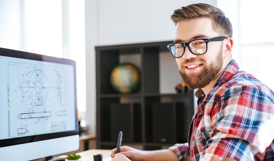 Junger Ingenieur arbeitet am Computer an technischen CAD-Zeichnungen im modernen Büro