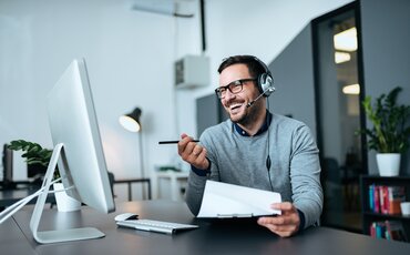 Geschäftsmann mit Headset arbeitet an Laptop – Weiterbildung Digitale Transformation an der IHK Akademie München zur erfolgreichen digitalen Unternehmensentwicklung.