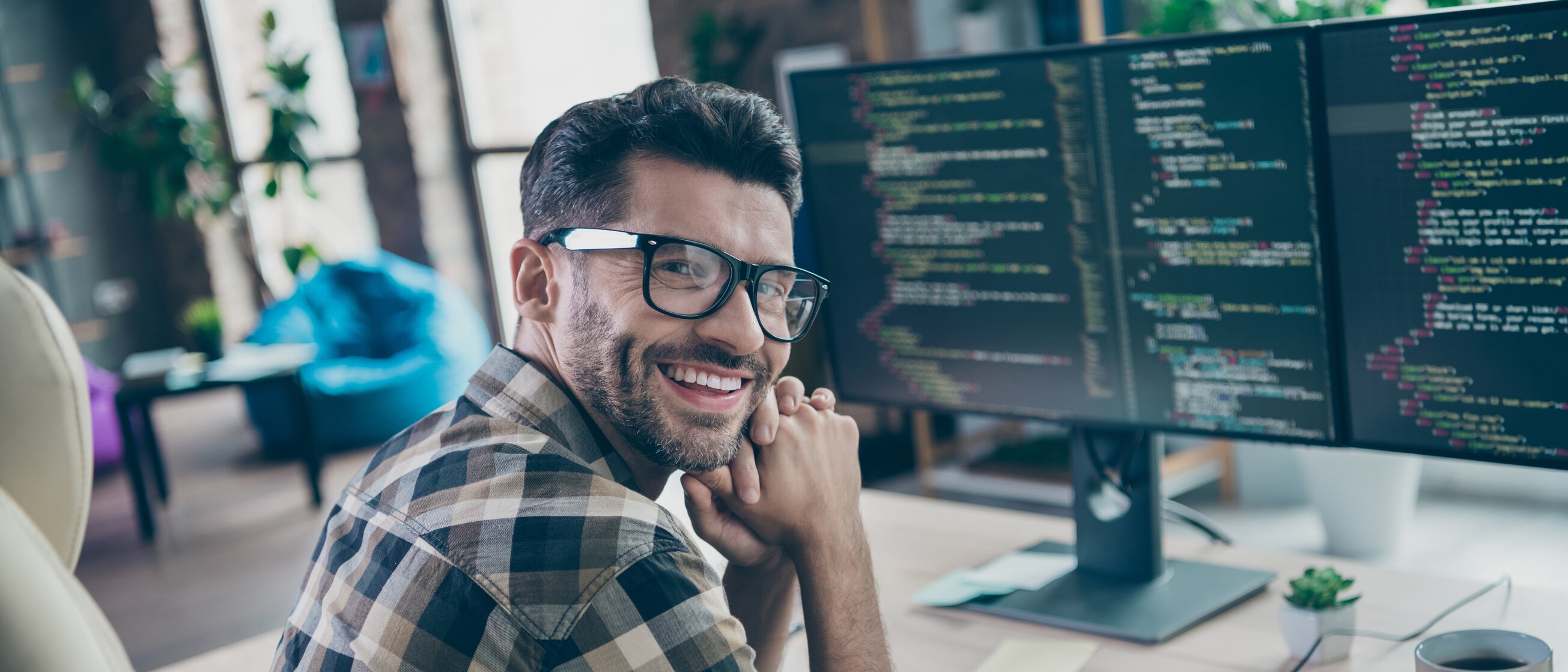 Mann arbeitet am Computer und lächelt – Symbol für praxisnahe Weiterbildung im Bereich Datenschutz und Informationssicherheit bei der IHK Akademie München.