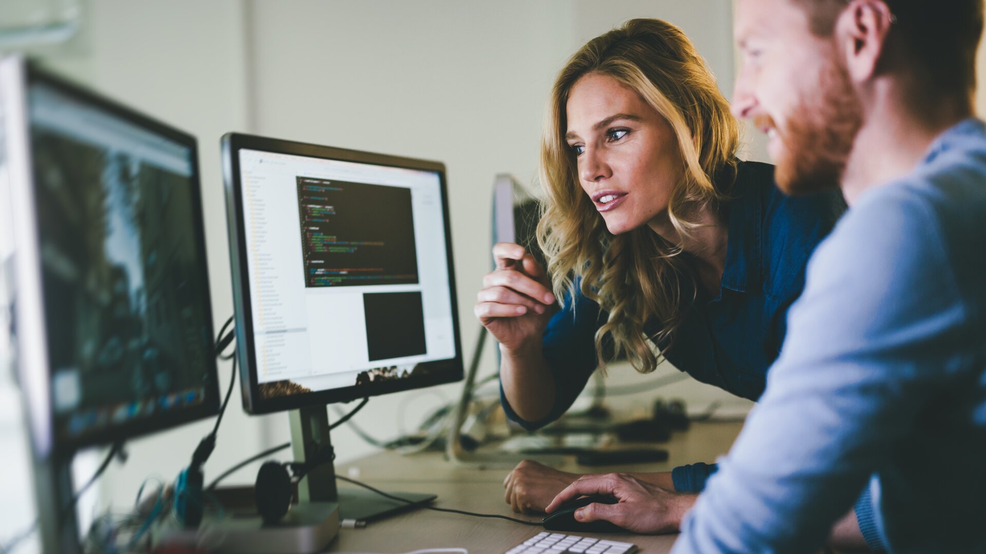 Zwei Softwareentwickler arbeiten gemeinsam am Computer an einem Programmierprojekt.