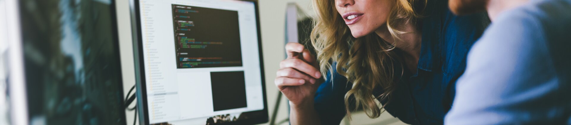 Zwei Softwareentwickler arbeiten gemeinsam am Computer an einem Programmierprojekt.