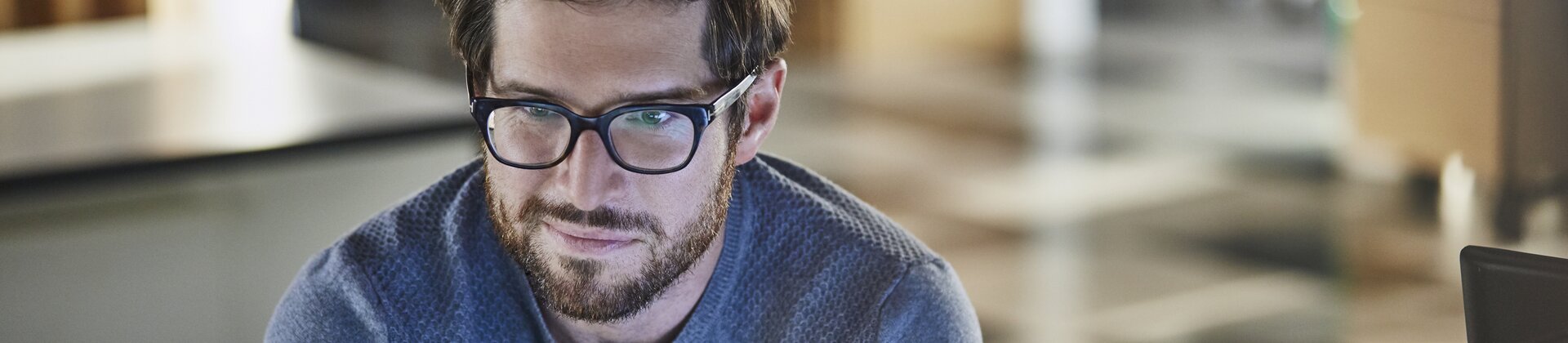 Programmierer arbeitet konzentriert am Computer in einem modernen Büro.