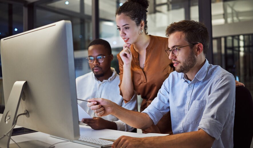 Team von IT-Mitarbeitern arbeitet gemeinsam an einem Computerprojekt im modernen Büro.
