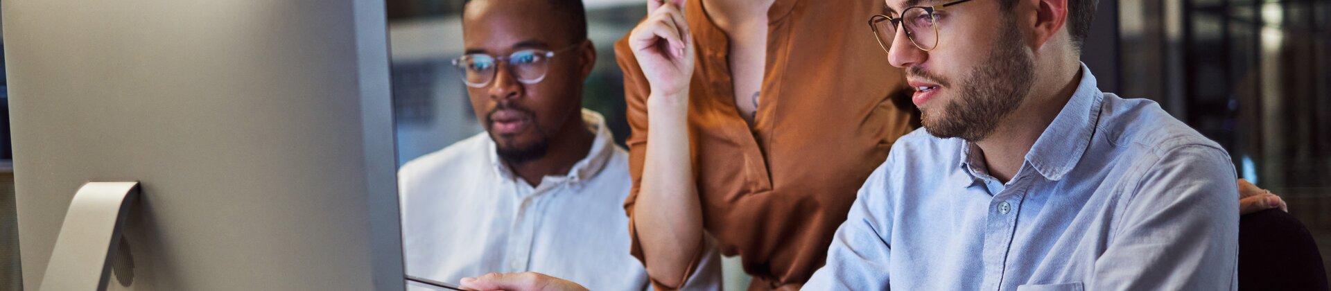 Team von IT-Mitarbeitern arbeitet gemeinsam an einem Computerprojekt im modernen Büro.