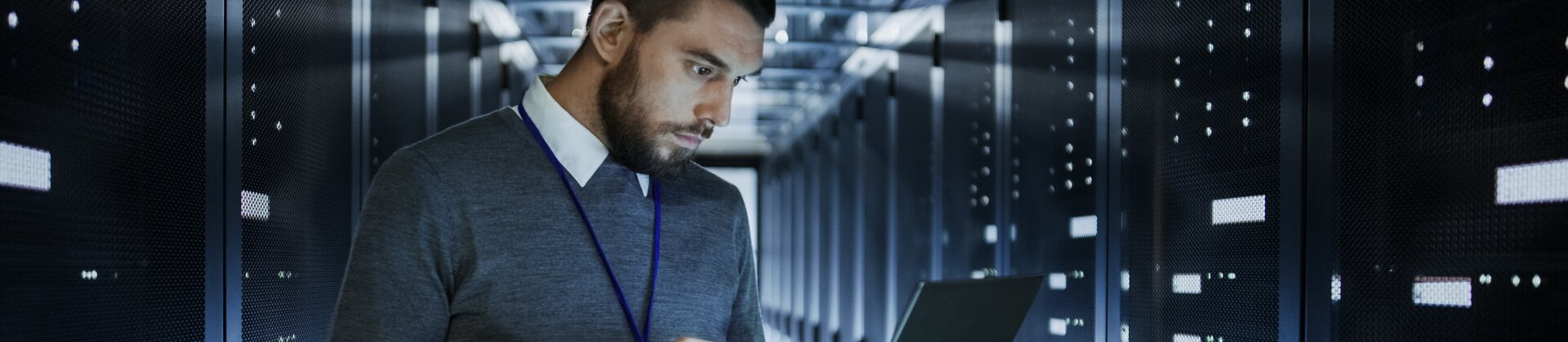 IT-Techniker überprüft Serverracks im Rechenzentrum mit Laptop