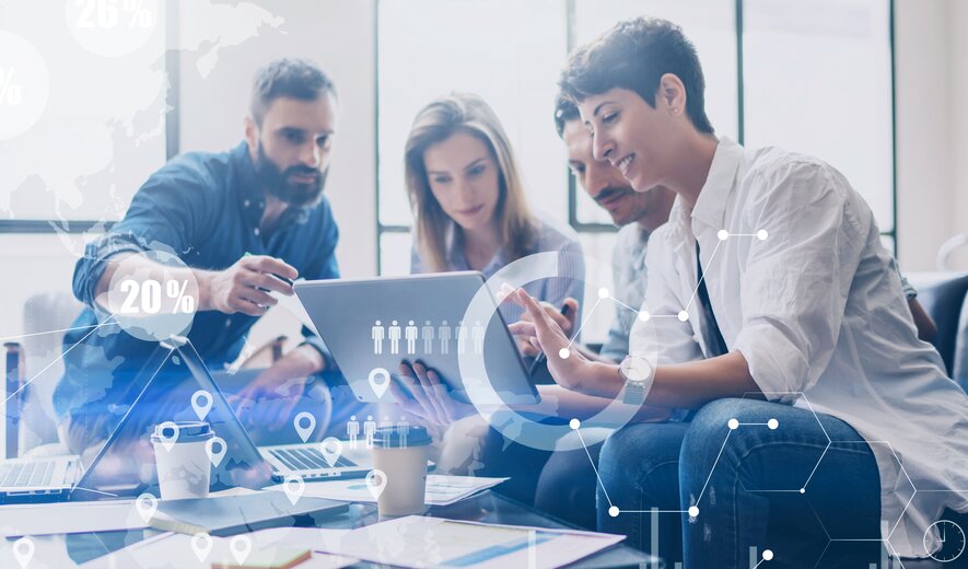 Team arbeitet gemeinsam an digitalen Daten und Statistiken auf einem Laptop