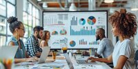 Teammeeting im modernen Büro mit Laptops, große Daten- und Diagrammvisualisierung auf Bildschirm im Hintergrund