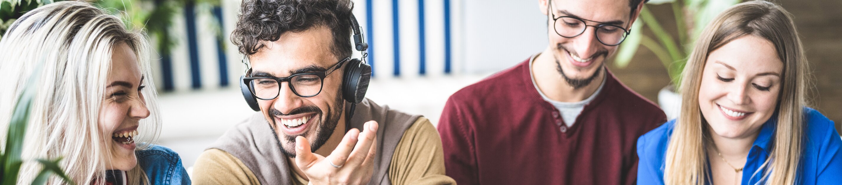 Gruppe junger Content-Creator beim gemeinsamen Produzieren von Social-Media-Inhalten am Tisch