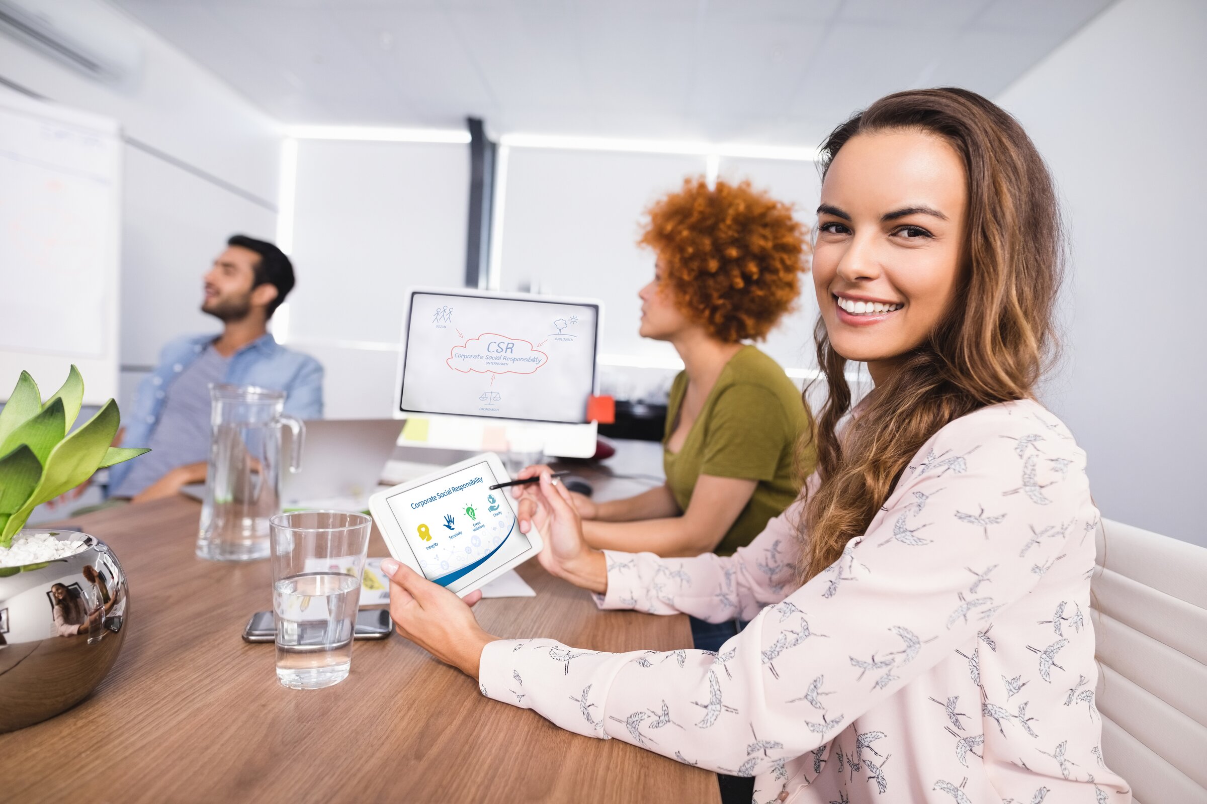 Weiterbildung im Bereich Gesundheit: Ein Praxisteam sitzt an einem Schreibtisch und schaut eine Präsentation an.