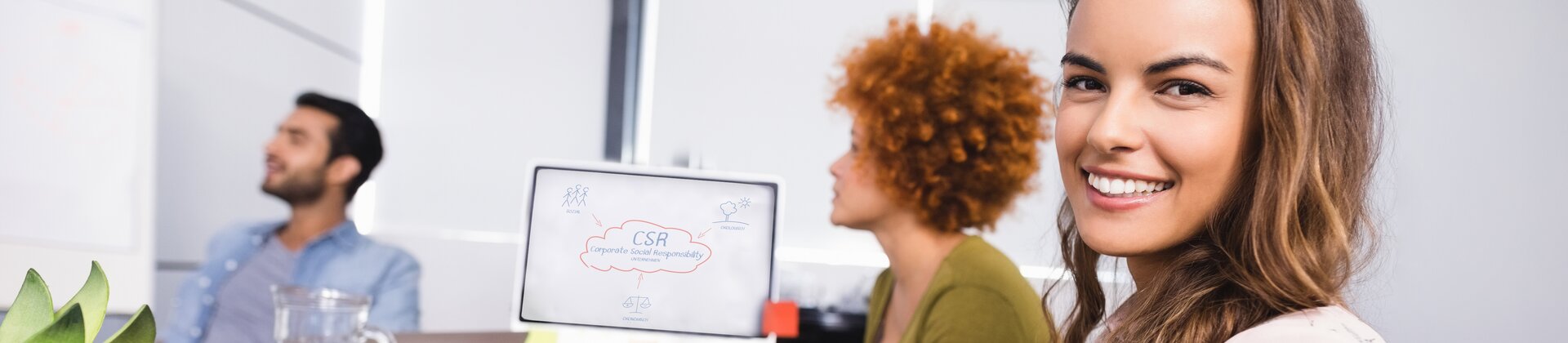 frau im büro mit tablet und team bei der projektdiskussion