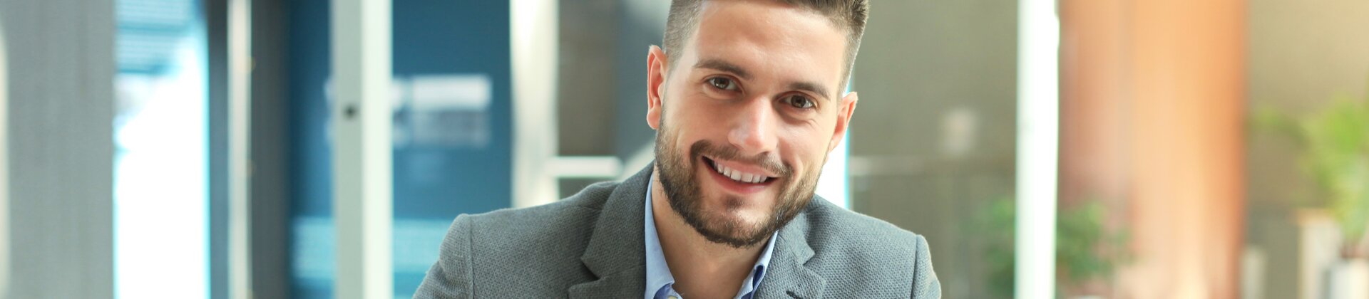 business mann am schreibtisch mit laptop und unterlagen