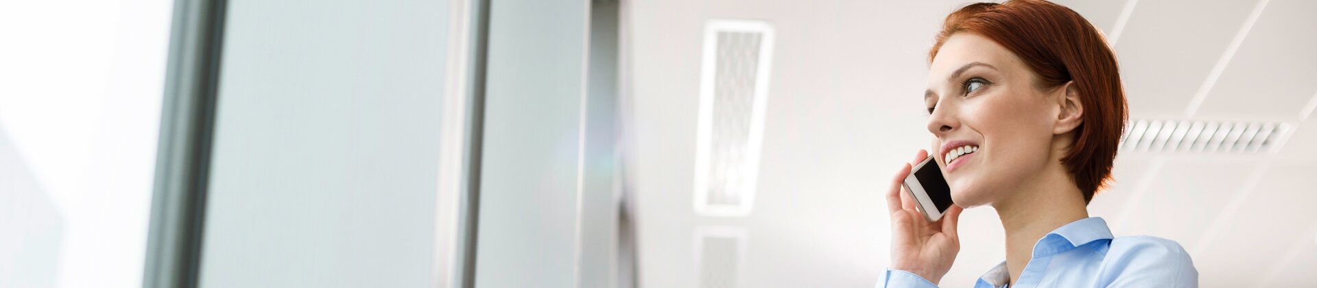 businessfrau telefoniert im büro und hält eine rote mappe