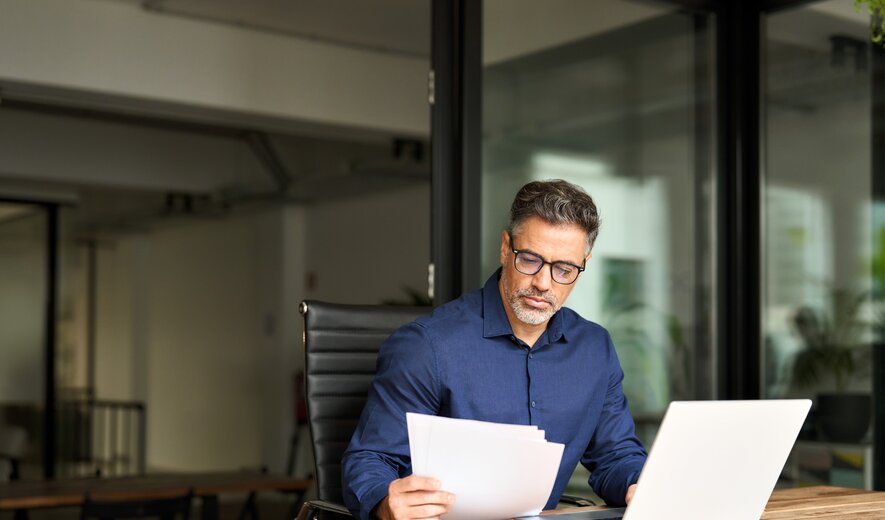 geschäftsmann arbeitet im büro an unterlagen und laptop