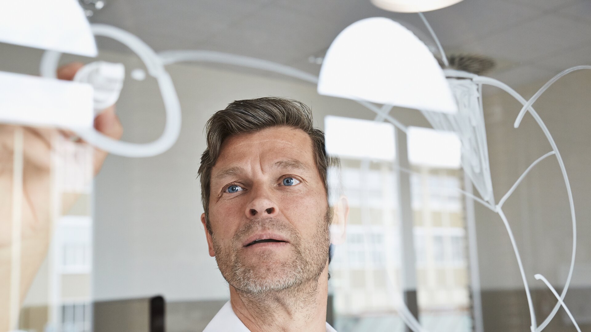 mann zeichnet diagramm auf glaswand