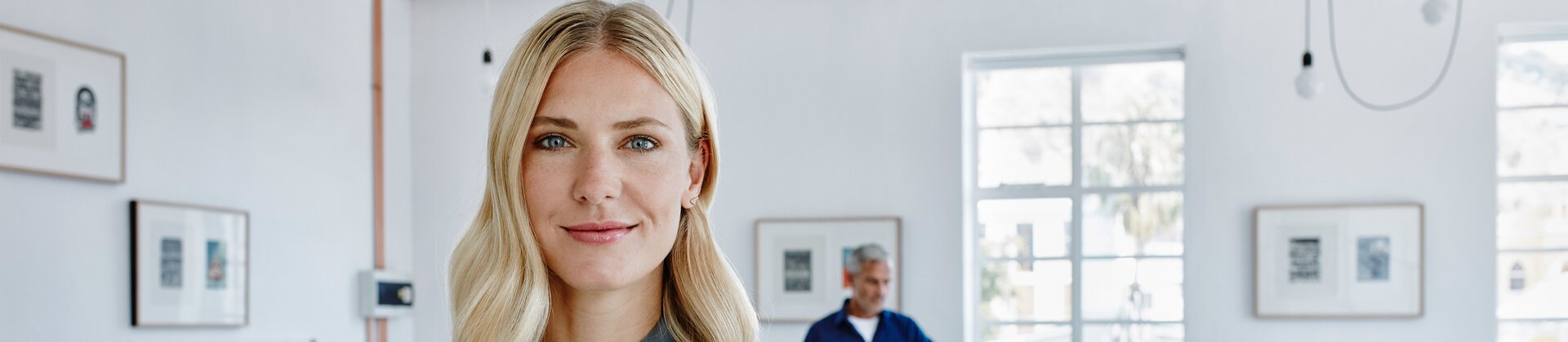 Führungskraft im modernen Büro steht selbstbewusst vor ihrem Team