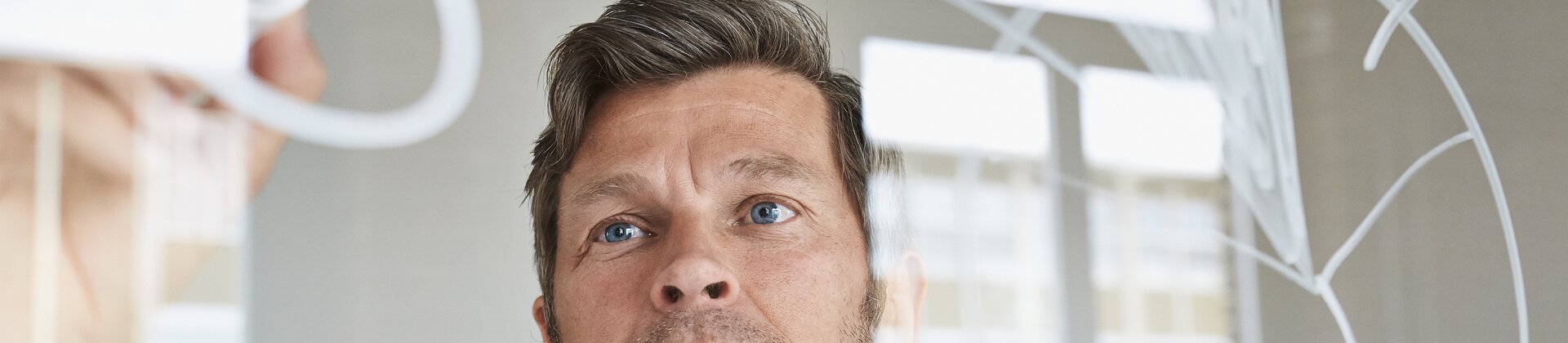 mann zeichnet diagramm auf glaswand