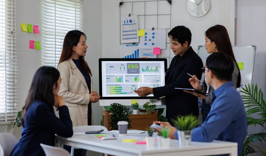 Gruppe von Fachkräften analysiert ESG-Dashboard im Rahmen einer Weiterbildung zu Nachhaltigkeitsmanagement