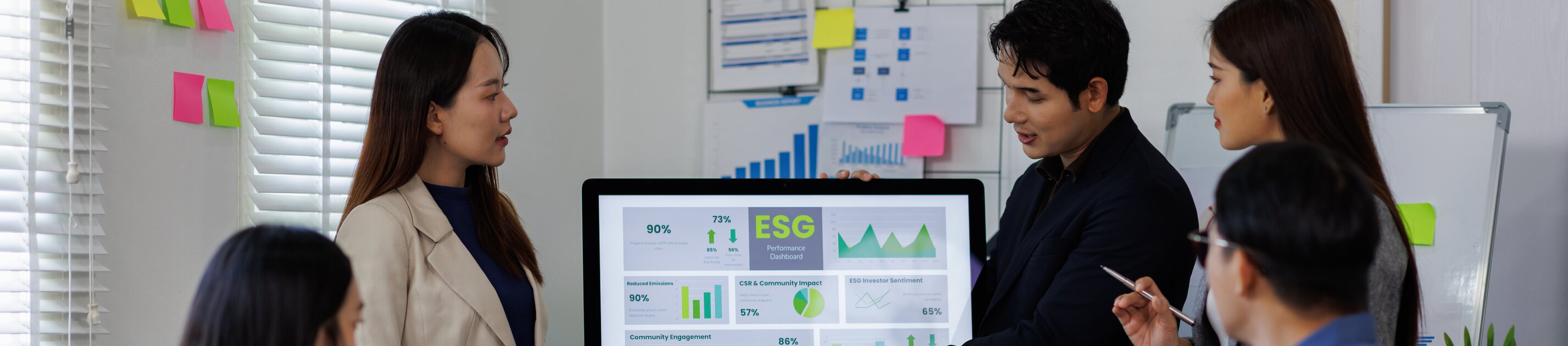 Gruppe von Fachkräften analysiert ESG-Dashboard im Rahmen einer Weiterbildung zu Nachhaltigkeitsmanagement