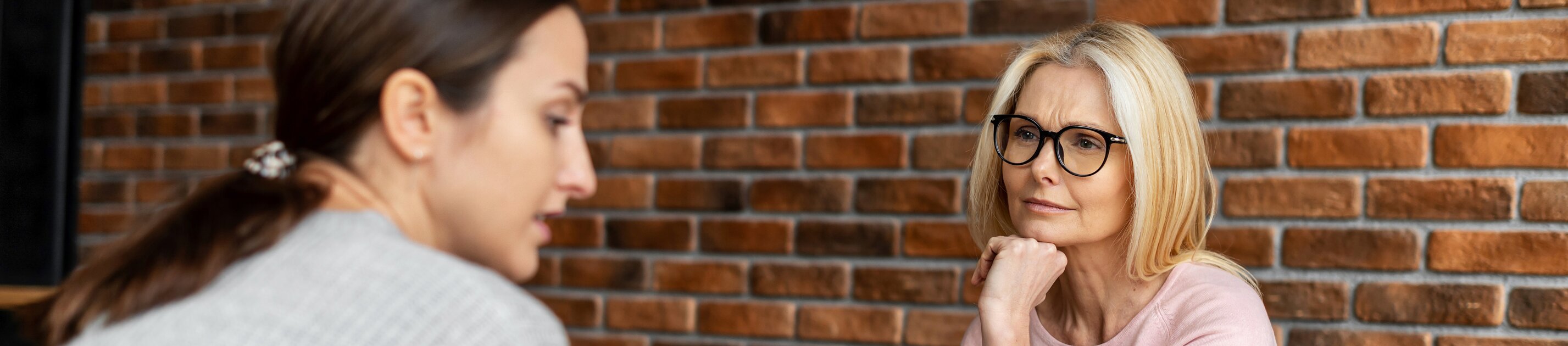 Beraterin führt empathisches Gespräch mit Klientin in modernem Büro